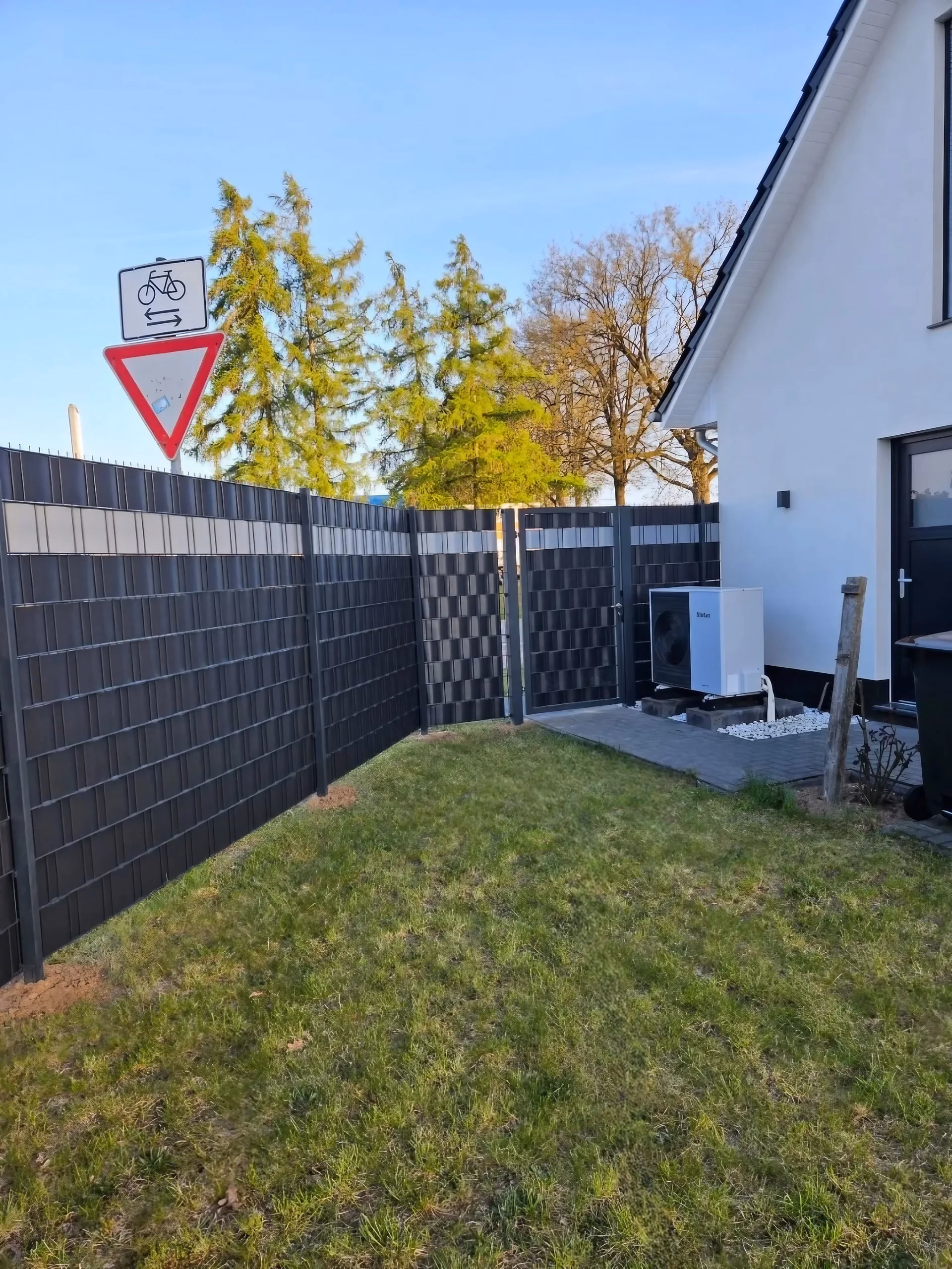 Doppelstabmattenzaun in Anthrazit mit Sichtschutzstreifen am Garten mit Wärmepumpe